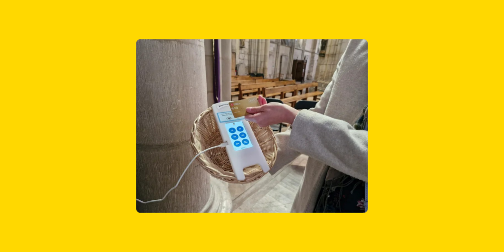 Don par carte bancaire via un terminal de paiement sans contact, placé dans un panier de collecte à l’intérieur d’une église.